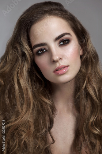 Young beautiful girl with long curly hair and smoky eyes