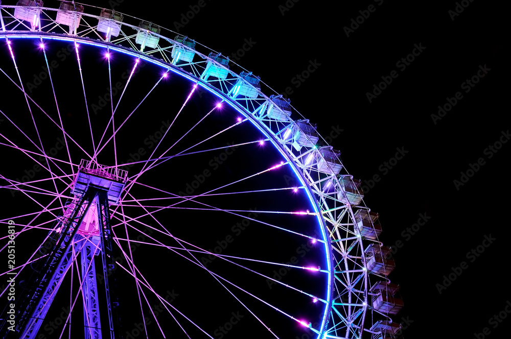Big ferris wheel with festive purple and blue illumination