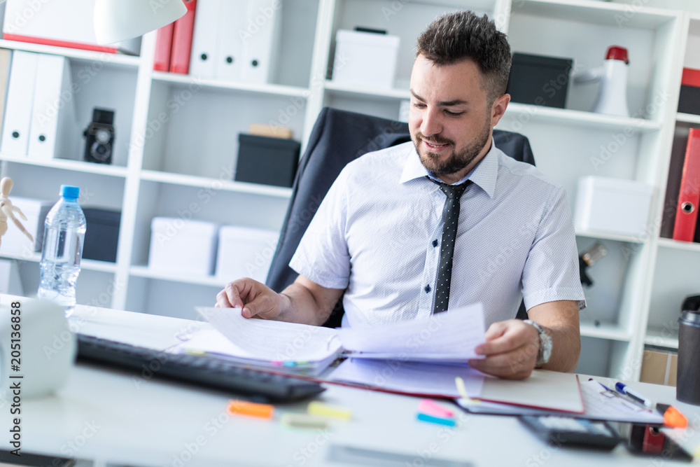 A man is sitting in the office and working with documents. A man is sitting in the office and working with documents.