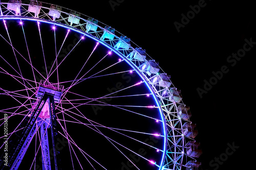Big ferris wheel with festive purple and blue illumination