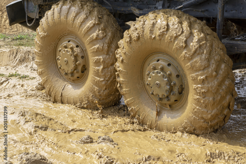 big wheels in the mud. The large wheels of a truck stuck in the mud. big wheels in the mud. The large wheels of a truck stuck in the mud.