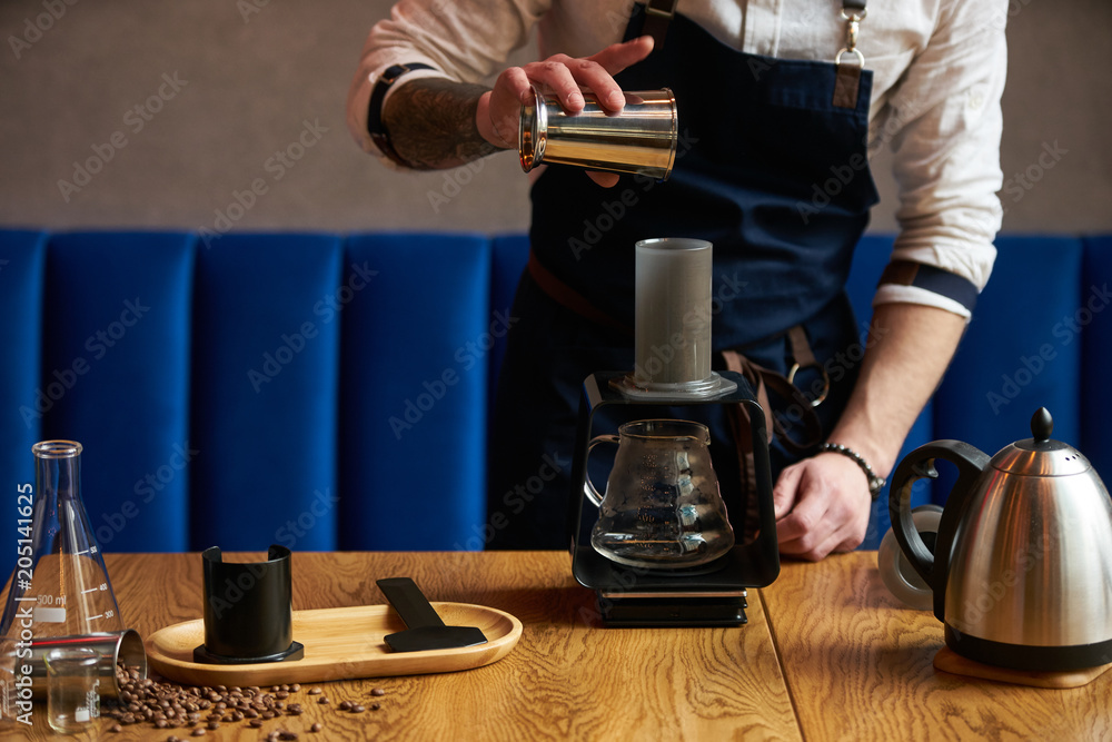 Barista prepare coffee at bar counter using different glassware and utensil, close-up