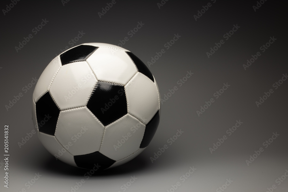 Fototapeta premium A classic white black soccer ball on a gray gradient background. There is a place for an inscription.