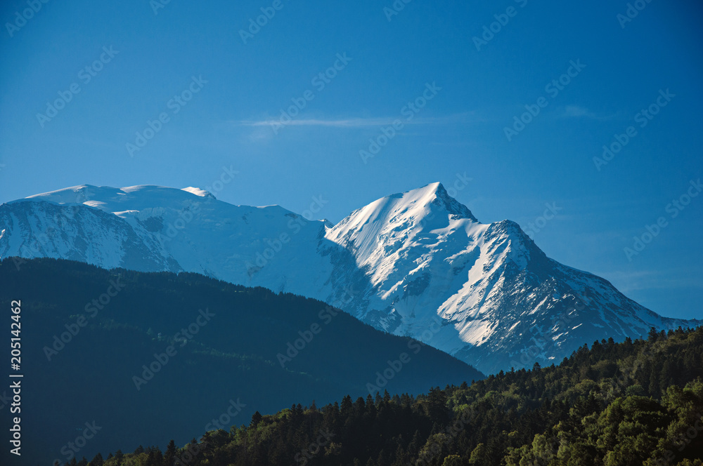 Alpine mountain landscape with forests and blue sky, near Saint-Gervais-Les-Bains. A famous ski resort located in Haute-Savoie Province, near the Mont Blanc in the French Alps.