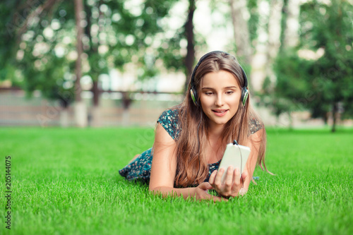 Front view of a fashion girl listening music with headphones and smart phone