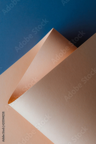 close-up view of beautiful tender beige paper sheet on dark blue background
