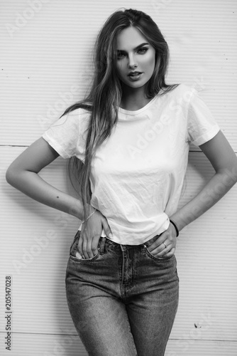 Beautiful girl in jeans and a T-shirt on the street. Black and white photo