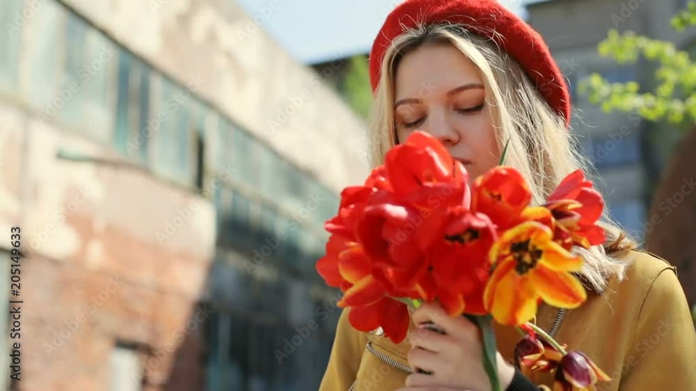 young successful business woman enjoying sunny day holding red tulips bouquet on street then smelling flowers and closing eyes pretty lady fashionable look modern urban lifestyle peaceful mood young successful business woman enjoying sunny day holding red tulips bouquet on street then smelling flowers and closing eyes pretty lady fashionable look modern urban lifestyle peaceful mood