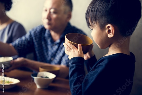 Japanese boy holding a bowl of soup
