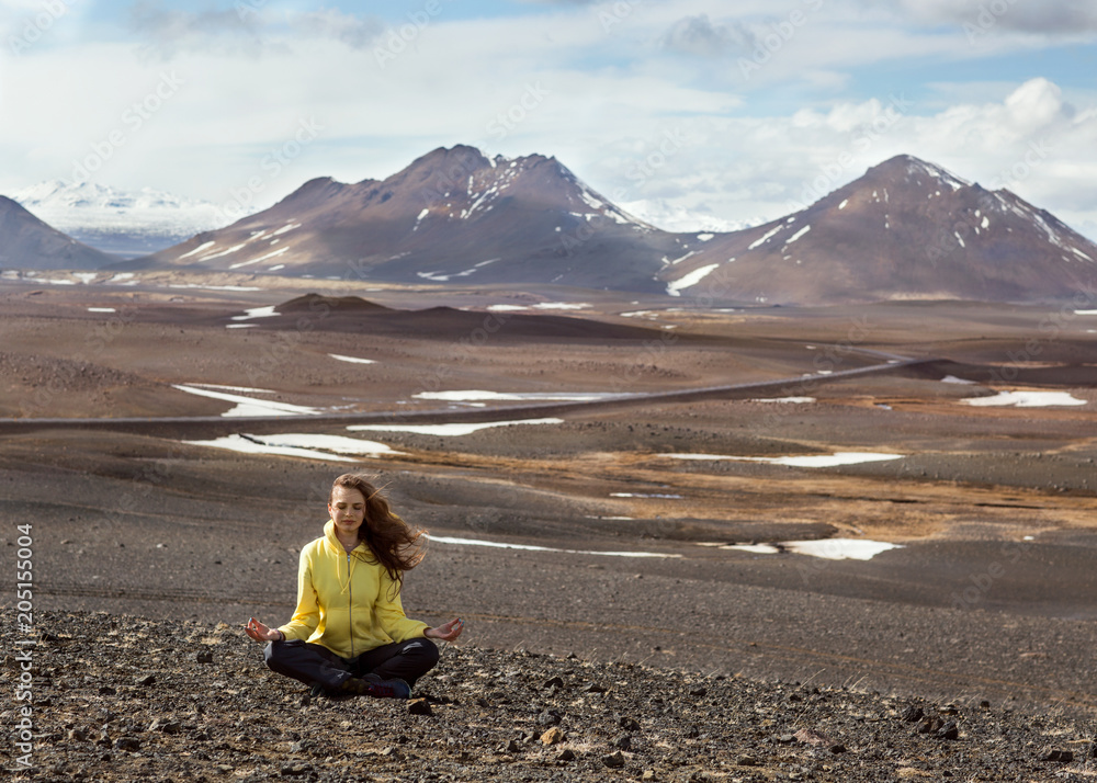 Fototapeta premium beautiful girl in yellow is engaged in yoga in the mountains of Iceland.