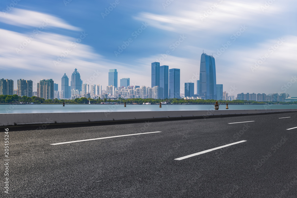 The empty asphalt road is built along modern commercial buildings in China's cities. The empty asphalt road is built along modern commercial buildings in China's cities.