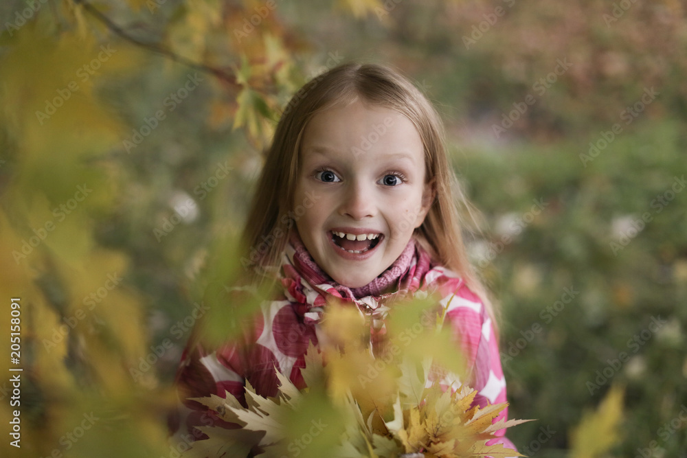 Portrait of a Happy smiling little girl looking at the camera in the autumn park. Cute four years old child enjoying nature outdoors. Portrait of a Happy smiling little girl looking at the camera in the autumn park. Cute four years old child enjoying nature outdoors.