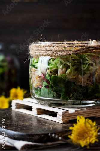 Salad from sprouts of sprouted soy and dandelion leaves in a jar © ekatherina