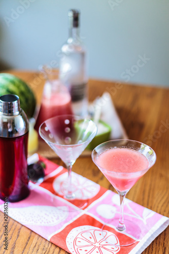 Making Pink Watermelon Martini for Happy Hour on Wooden table or bar