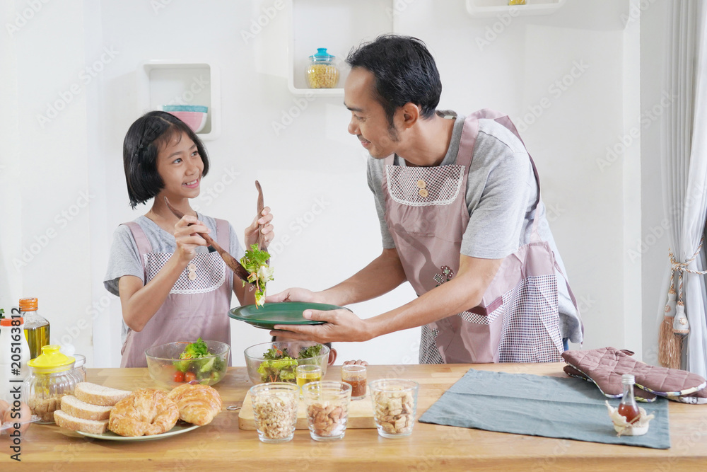 Father and daughter cooks in the kitchen at home, happy family asian concept Father and daughter cooks in the kitchen at home, happy family asian concept