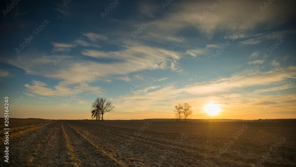 Beautiful evening colorful sky over plowed fields