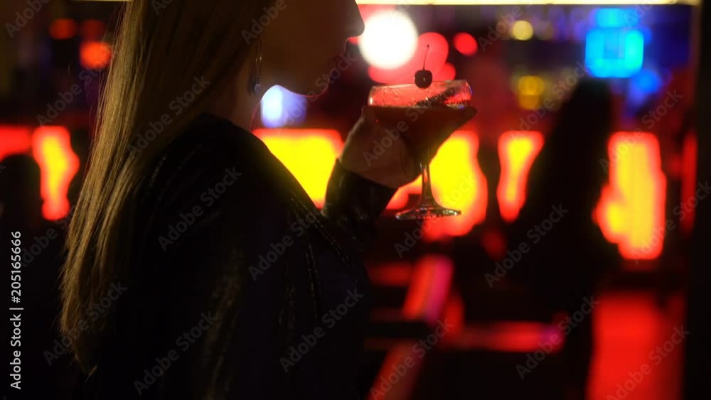 Pretty long haired woman drinking cocktail at night club, looking for date Pretty long haired woman drinking cocktail at night club, looking for date