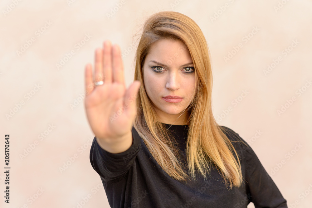 Blond woman showing hand stop gesture Blond woman showing hand stop gesture