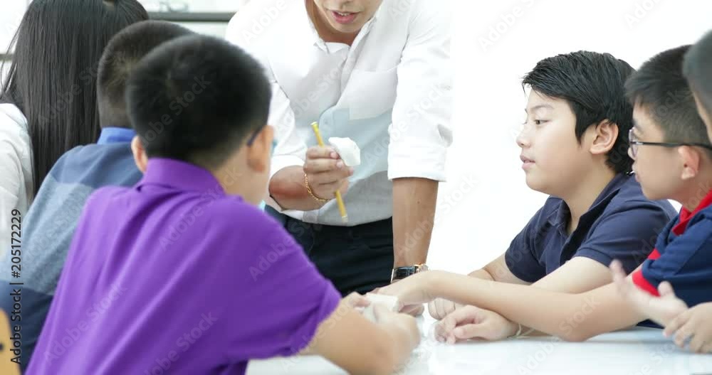 Asian teacher expanding to student in geology class with different of rock . Asian teacher expanding to student in geology class with different of rock .