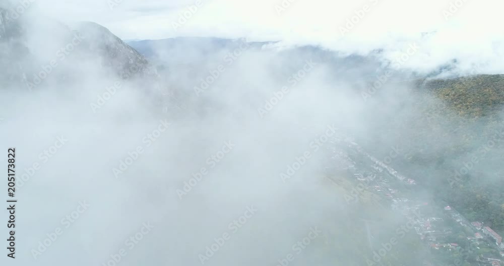 Aerial shot of town in mountains, through clouds - Baile Herculane, Transylvania Aerial shot of town in mountains, through clouds - Baile Herculane, Transylvania