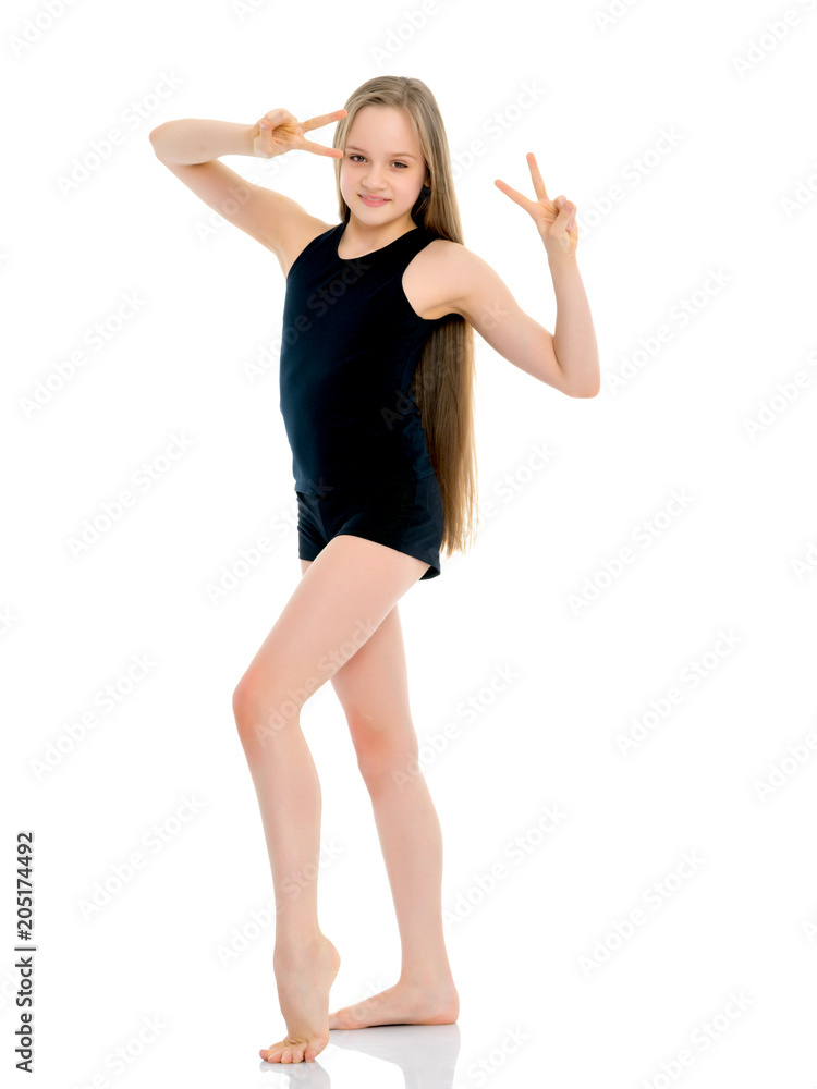 Girl gymnast in a black T-shirt and shorts prepare for the exerc