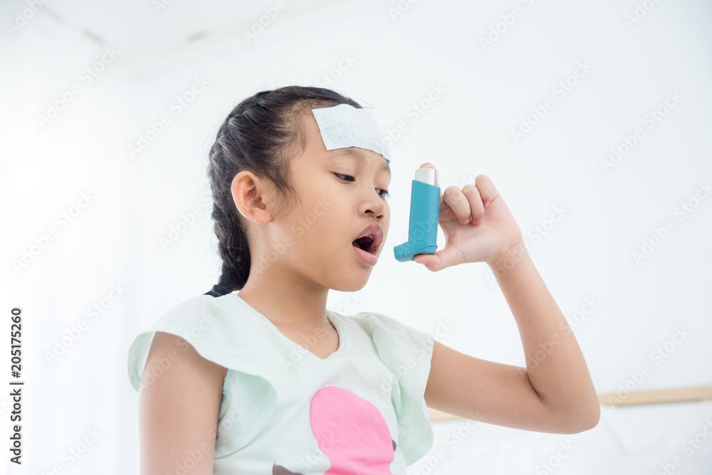 Young asian girl using inhaler for relief asthma attack Young asian girl using inhaler for relief asthma attack