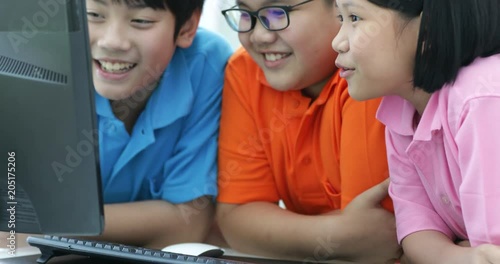 Close up of Smiling asian pupils using a desktop computer in the classroom with smile face.