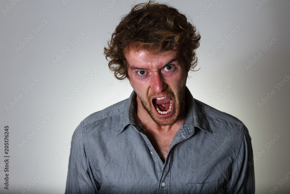 Mad young man screaming in anger Mad young man screaming in anger