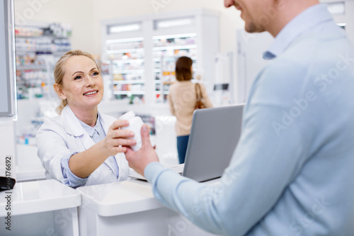 Try this. Attractive female pharmacist assisting man and looking at him