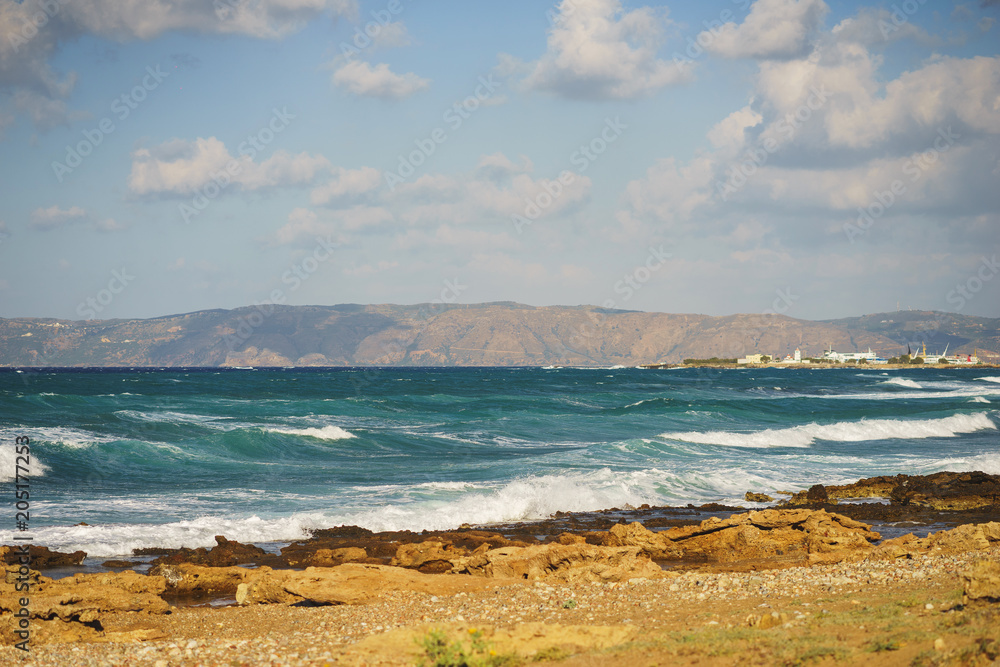 Beautiful seascape with blue sea waves on a rocky beach, Crete, Greece.