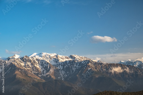 the tops of the mountain ranges snow-covered in the clouds of the Karachay-Cherkess Republic  the Caucasus  in the spring evening