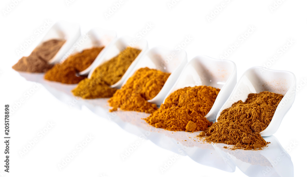 Small ceramic bowls of Indian spices isolated on white background. Small ceramic bowls of Indian spices isolated on white background.