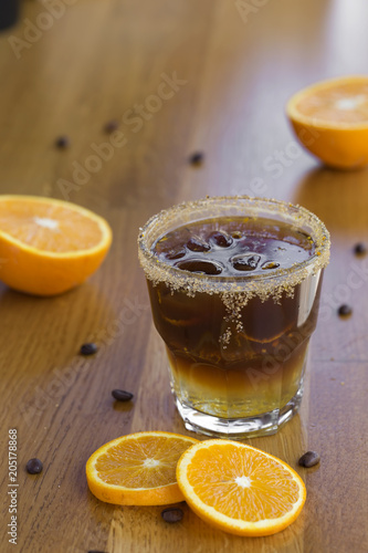 Cold coffee with brown sugar, orange and ice cubes
