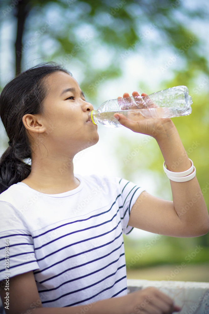 asian teenager drinking water from plastic bottle asian teenager drinking water from plastic bottle