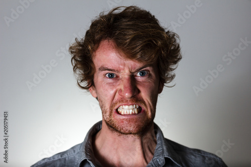 Fototapeta Angry young man with clenched teeth