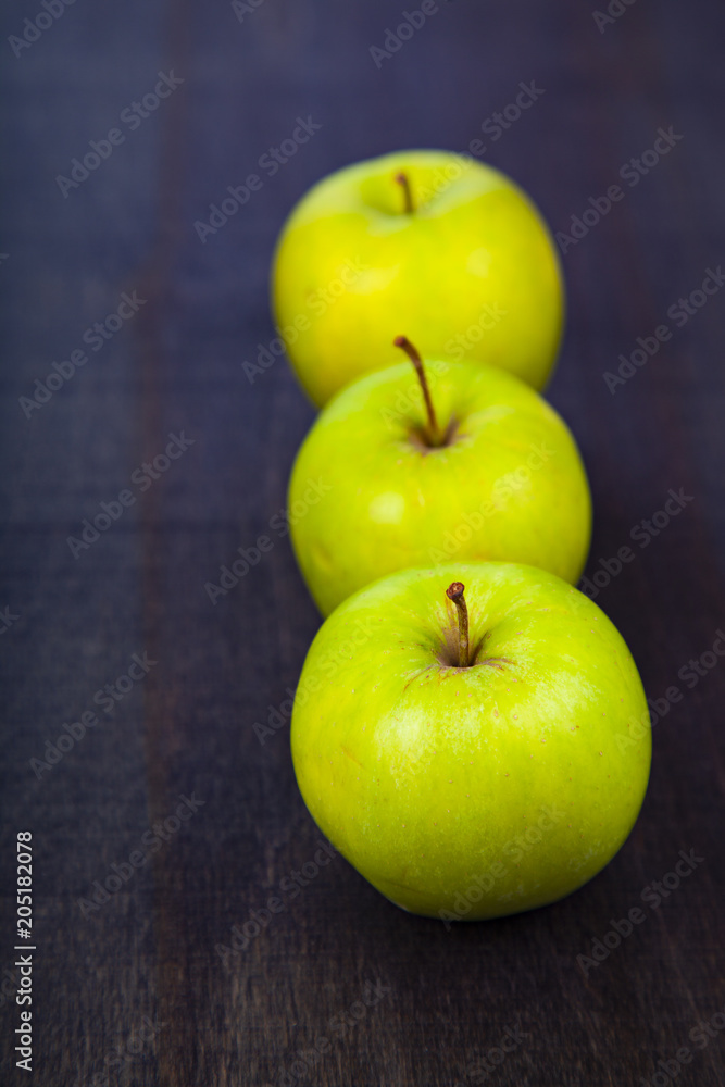Three apples on a dark wooden background Three apples on a dark wooden background