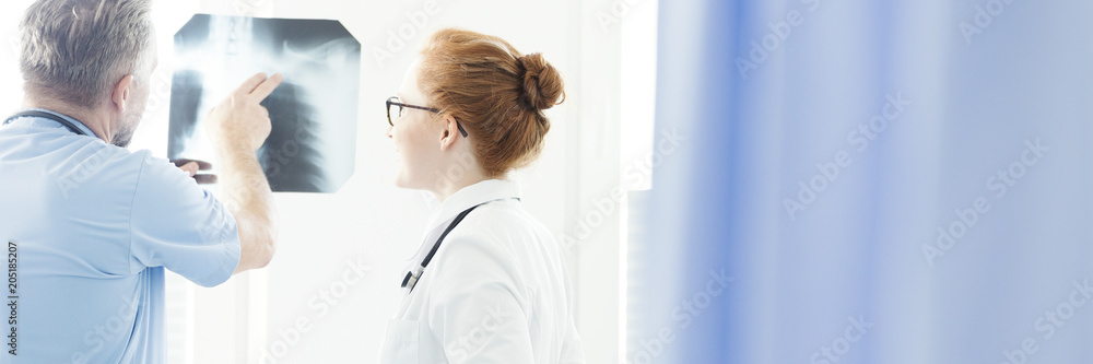 Orthopedist pointing to X-ray results Orthopedist pointing to X-ray results