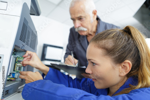 electromechanical technician repairing an appliance photo