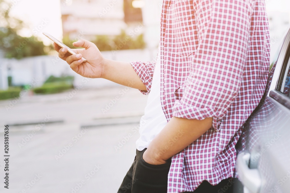 Young man leaning on his car, using mobile smart phone, call a car mechanic ask for help assistance because car broken. Young man leaning on his car, using mobile smart phone, call a car mechanic ask for help assistance because car broken.