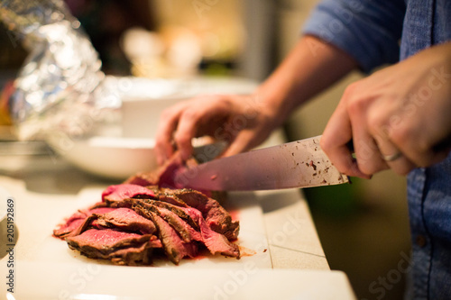 Slicing Red Steak Beef knife hand blue shirt