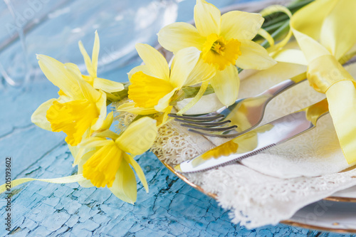 Fototapeta Naklejka Na Ścianę i Meble -  Set of tableware and a bouquet of yellow narcissus