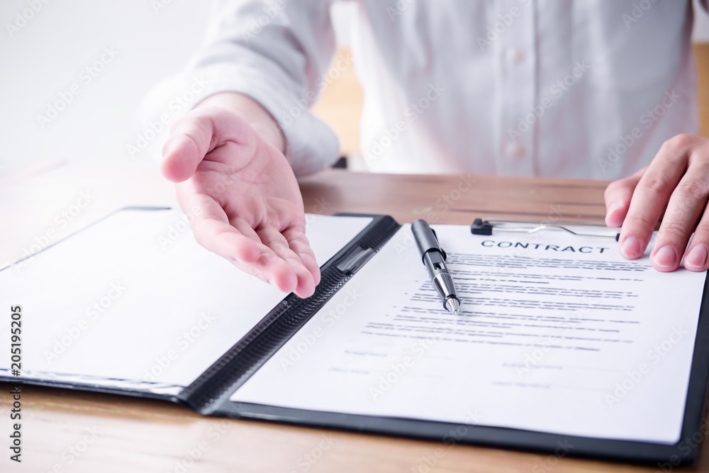 Close up business man reaching out sheet with contract agreement proposing to sign.Full and accurate details, individual who owns the business sign personally,director of the company, solicitor. Close up business man reaching out sheet with contract agreement proposing to sign.Full and accurate details, individual who owns the business sign personally,director of the company, solicitor.