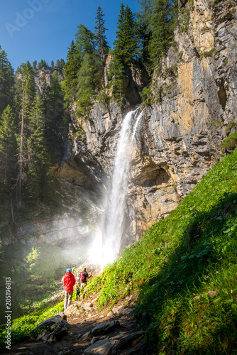 Hiker in front of an impressive waterfall photo