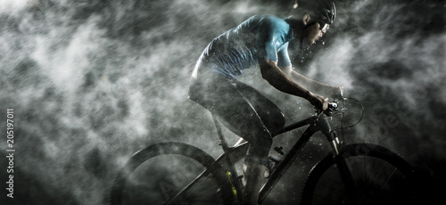 Fototapeta Cyklisty kolarstwo na rowerze górskim z dżdżystym, mgłowym na czarnym tle.