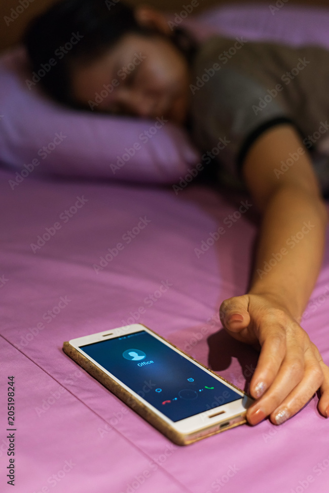 Asian woman waking up grabbing mobile phone Asian woman waking up grabbing mobile phone