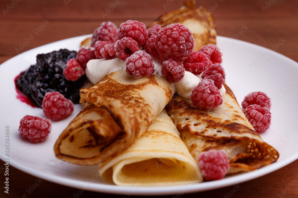 tasty home made pancakes with ice cream on craft wood table decorated with jam, raspberries and nuts tasty home made pancakes with ice cream on craft wood table decorated with jam, raspberries and nuts