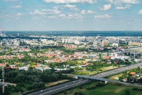 Fototapeta Naklejka Na Ścianę i Meble -  Aerial picture of city with houses and gardens, crossroads and roads, houses, buildings, parks and parking lots, bridges. Airplane drone shot.