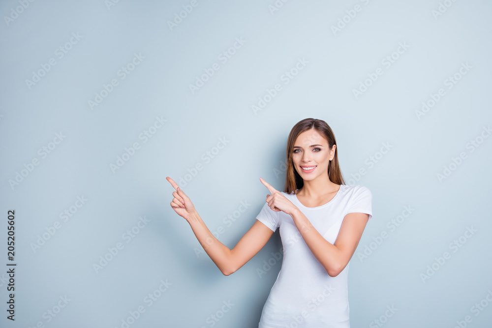 Portrait of charming confident girl in white t-shirt poiting two forefingers to empty place, copy space looking at camera isolated on grey background Portrait of charming confident girl in white t-shirt poiting two forefingers to empty place, copy space looking at camera isolated on grey background