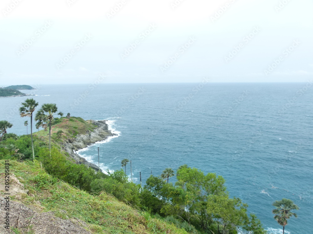 Promthep Cape is a landmark of Phuket Thailand; Sea, mountains and sugar palm