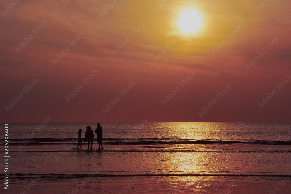 Familie im Sonnenuntergang am Strand von Callantsoog in den Niederlanden